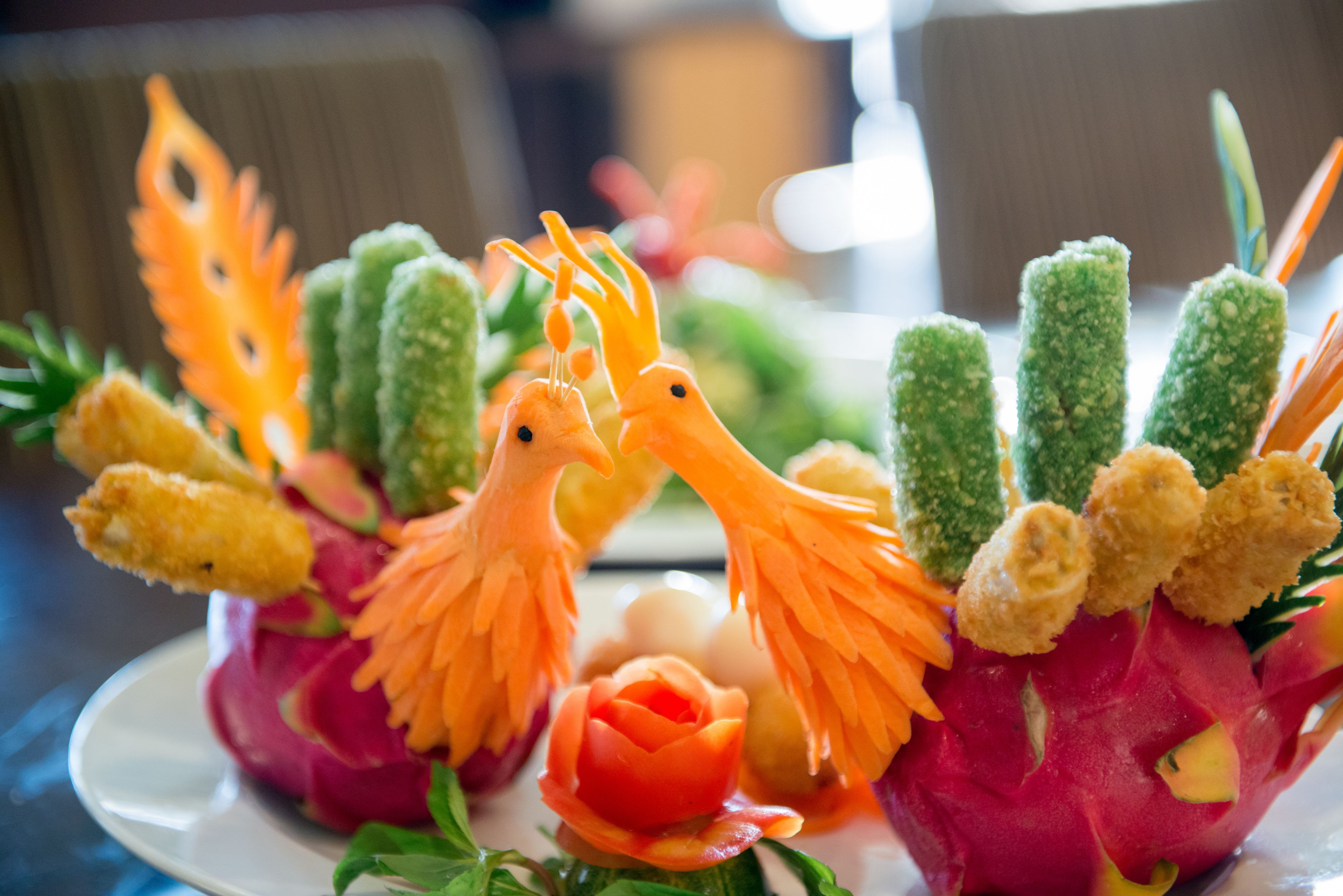 A dessert platter with intricately carved fruits and vegetables.