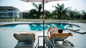 Un espace aménagé au bord de la piscine, avec des chaises longues et une piscine.