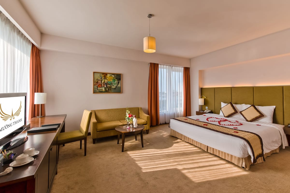 Une chambre d’hôtel équipée d’un lit, d’un canapé, d’un bureau et d’une télévision.