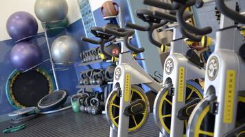 A gym with exercise equipment including treadmills, stationary bikes, and various weights.