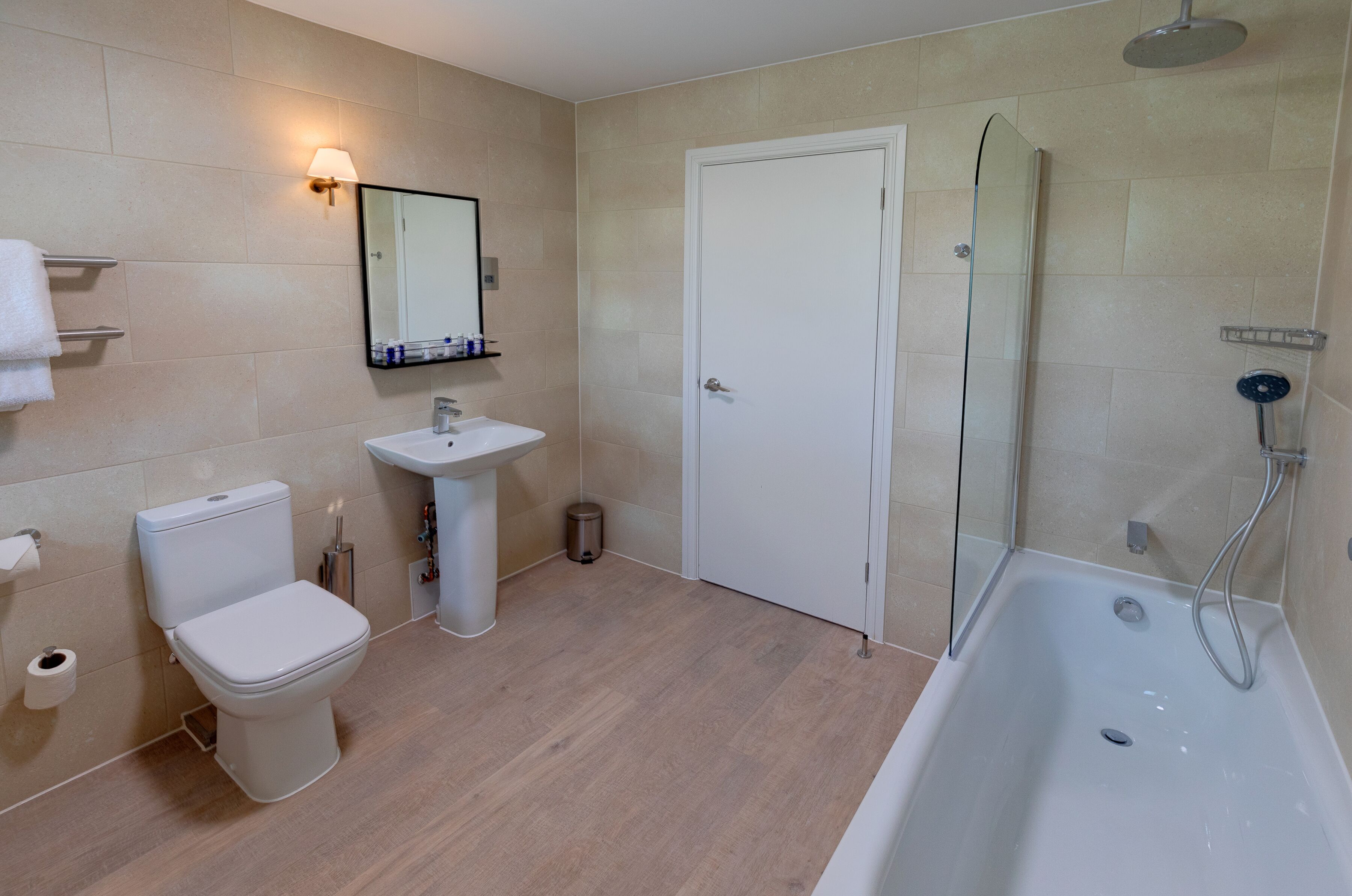 A modern bathroom with a toilet, sink, and shower.