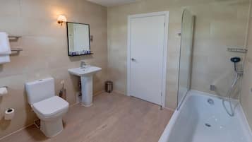 Un baño moderno con inodoro, lavamanos y ducha.