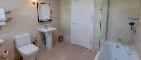 A modern bathroom with a toilet, sink, and shower.