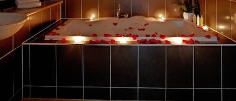 Un baño con bañera, lavabo y espejo.