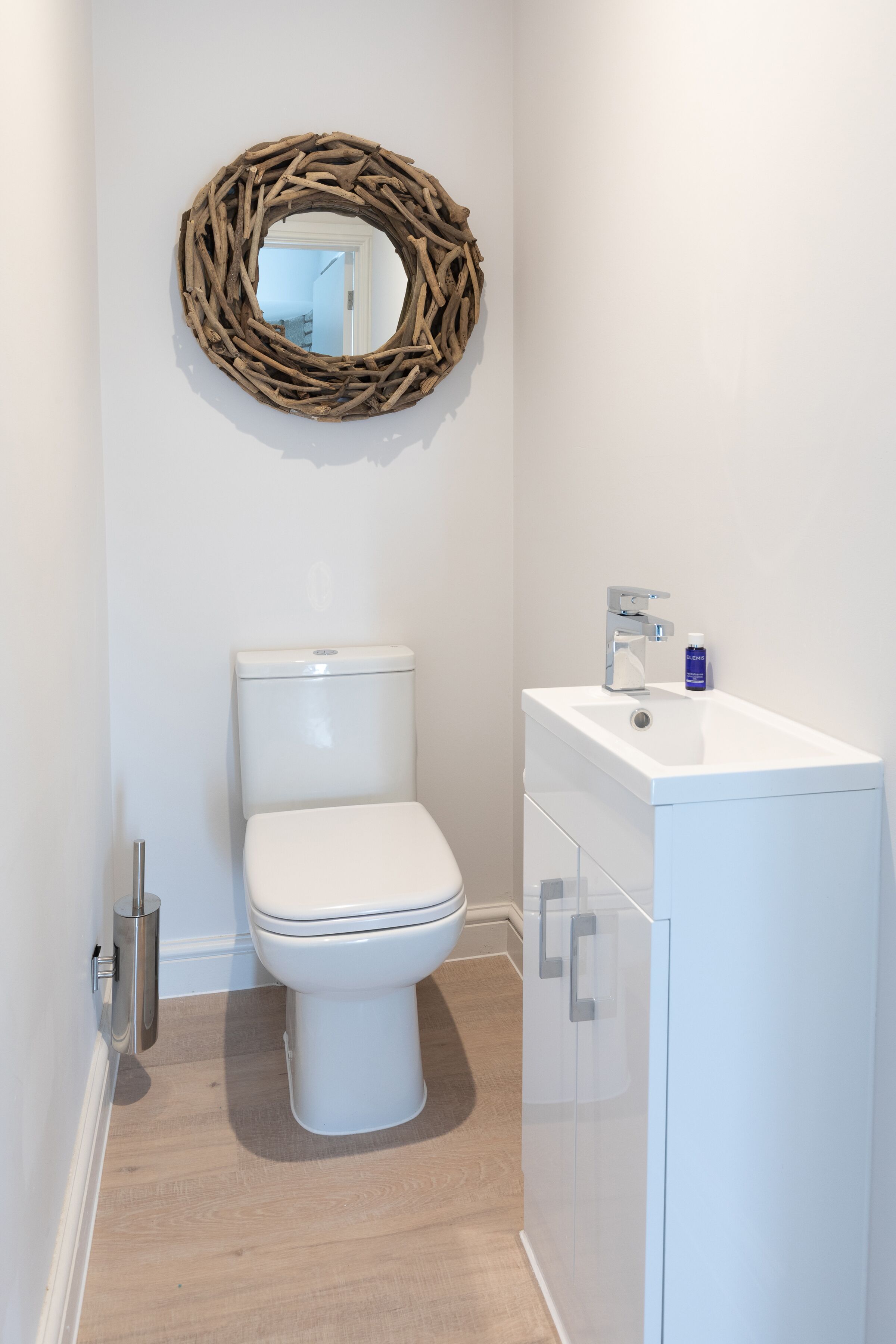 Een badkamer met een toilet, een wastafel en een spiegel.