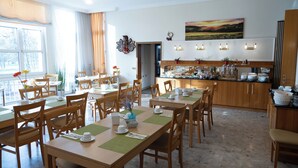 A hotel dining area with multiple tables, chairs, and a buffet setup. - Hotel Haus am Park (Bad Homburg v.d. Hoehe)
