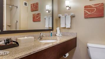 A bathroom with a sink, mirror, towel rack, and toilet.