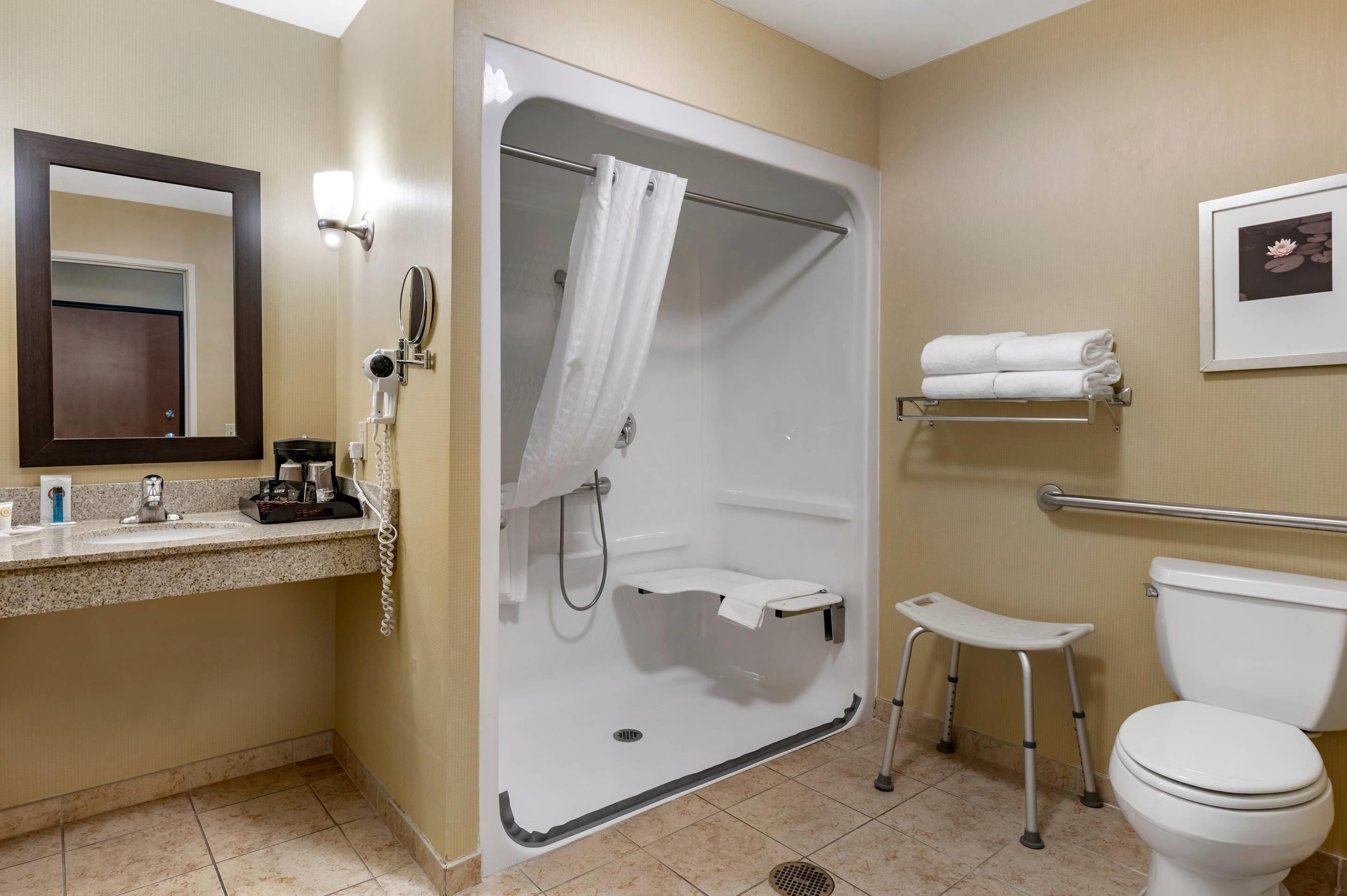 A bathroom with a shower, toilet, and sink.