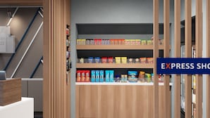 Pasillo de hotel con zona de kitchenette que ofrece snacks y bebidas.