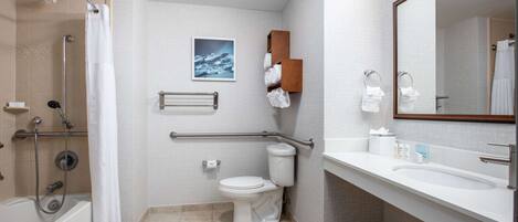 A modern bathroom with a shower, toilet, and sink.