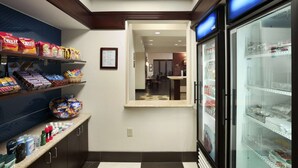 Eine Hotlellobby mit Snackregalen, einem Gefriertruhe und Blick in den Speisesaal.