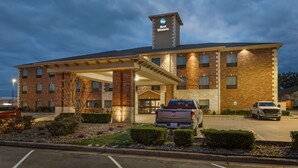 Een Best Western hotel met een gevel van baksteen, een overdekte ingang en een parkeerplaats met twee voertuigen.