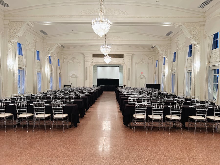 A large, ornate hall with rows of chairs and a stage at the front.