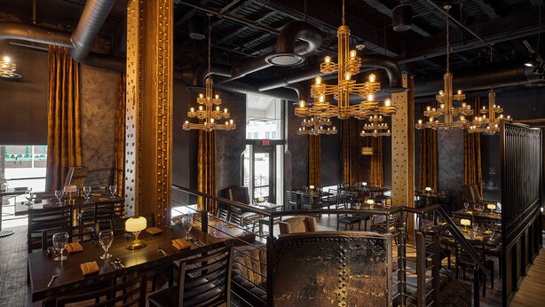 A restaurant with multiple dining tables, chairs, and hanging chandeliers. - The Mayo Hotel (Tulsa)