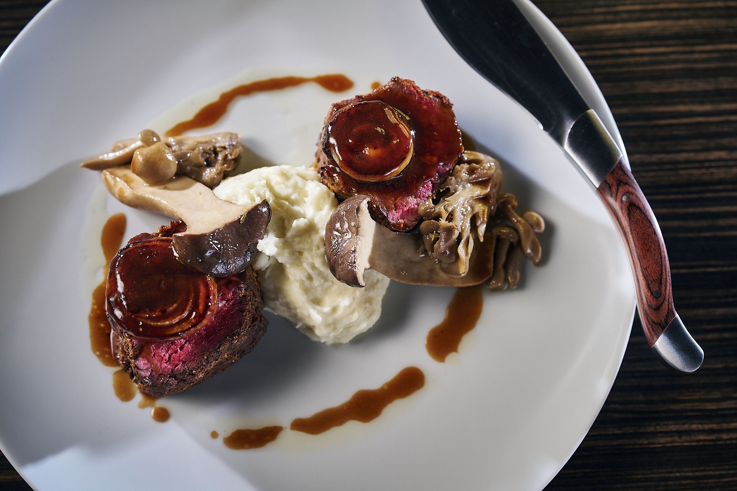 A plate of food with a knife on the side.