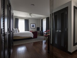 Una habitación de hotel con cama, escritorio, silla, televisor y armario.