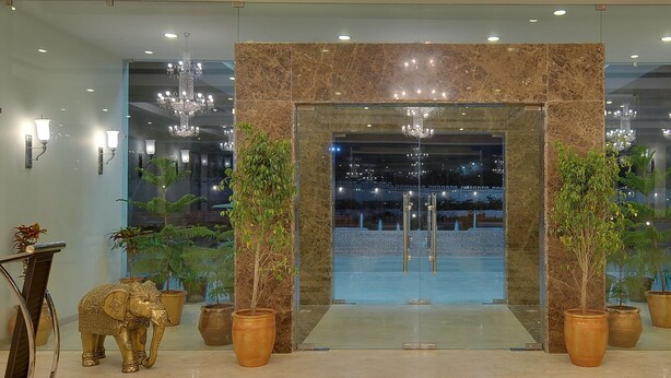 A lobby with a marble entrance, chandeliers, potted plants, and elephant statues. - Inder Residency Resort & Spa Udaipur (Udaipur)