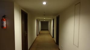 A long, narrow hotel corridor with carpeted floors and doors on both sides. - Minerva Grand Banjara Hills (Hyderabad)