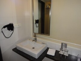 A bathroom with a white sink, a mirror, a towel rack, and a hairdryer.