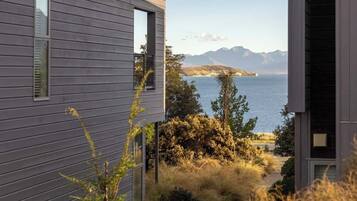 A modern house with a view of a lake and mountains.