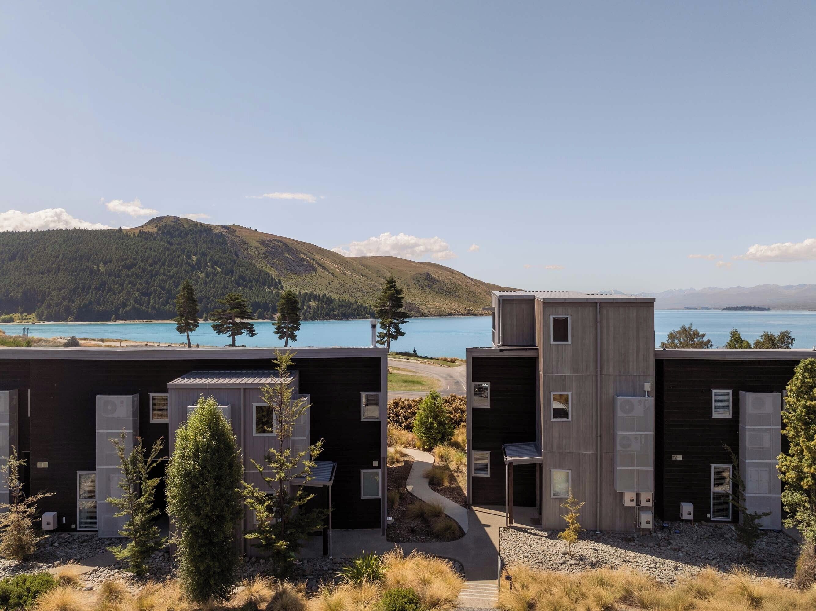 Un bâtiment moderne offrant une vue sur un lac et des montagnes.