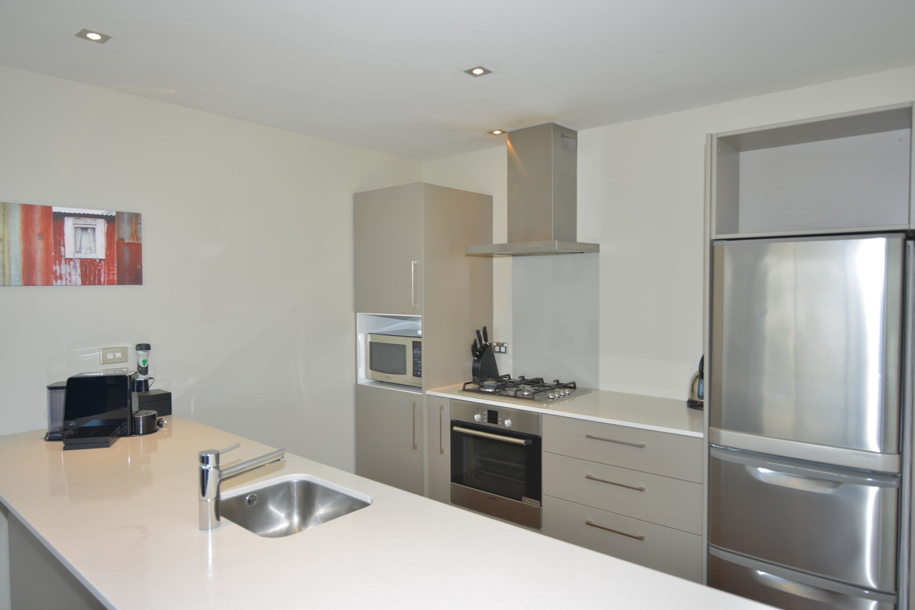 A modern kitchen with stainless steel appliances, a microwave, oven, and a sink.