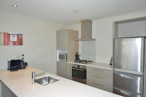 A modern kitchen with stainless steel appliances, a microwave, oven, and a sink.