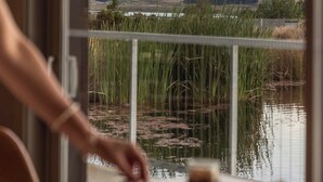 En person sitter vid ett bord med utsikt över berg och en sjö eller ett annat vattendrag.