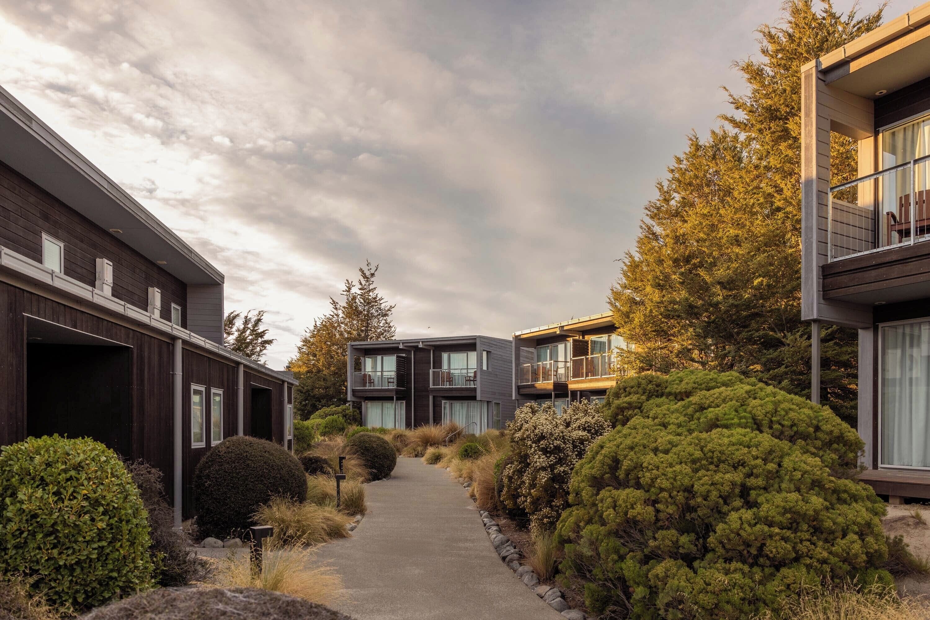 A modern residential area with two-story houses, a paved pathway, and well-maintained landscaping.