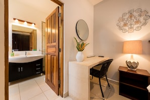 A bathroom with a sink, mirror, and a decorative wall piece.