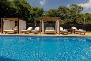 A poolside area with lounge chairs and a pergola structure.