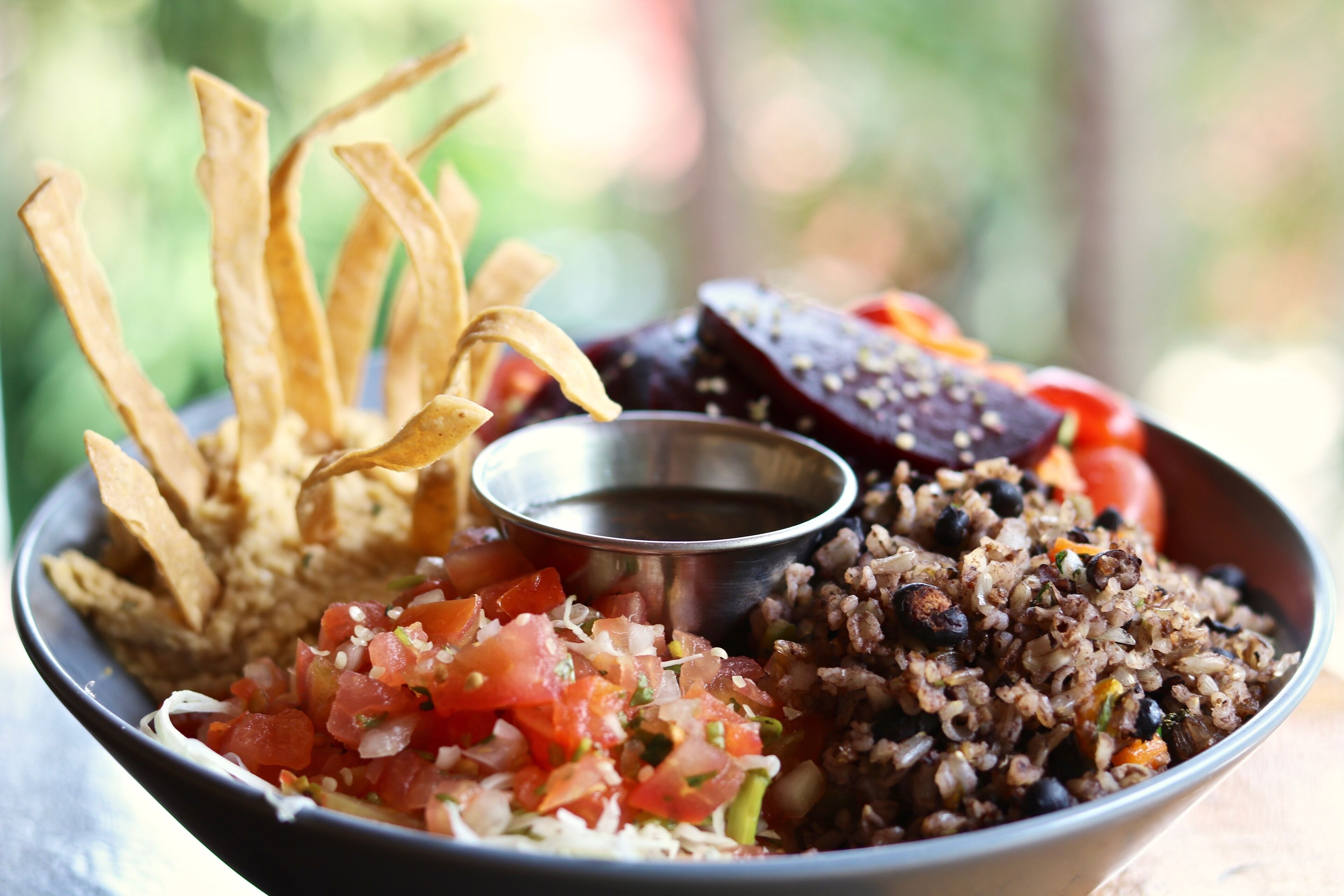 Un plato de comida con arroz, frijoles y salsa acompañante.
