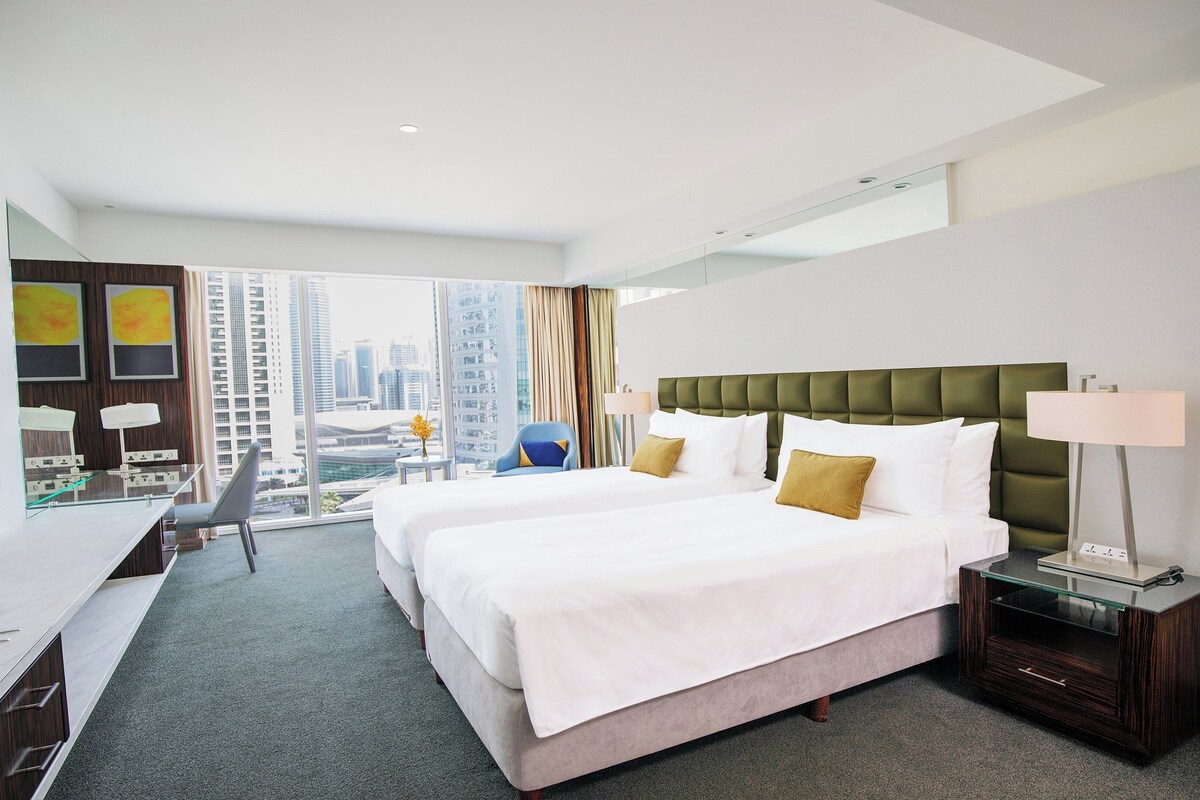 Ein Hotelzimmer mit einem großen Bett, einem Schreibtisch und einem Stuhl.