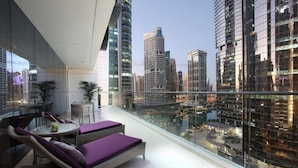 Eine moderne Dachterrasse mit Korbmöbeln und einer Glasumlaufung mit Blick auf die Stadt.