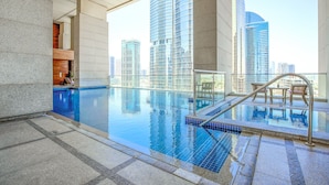 An indoor swimming pool with clear views of surrounding high-rise buildings. - voco Bonnington Dubai by IHG (Dubai)