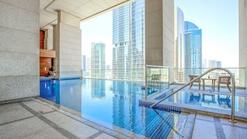 Una piscina al aire libre, sillones reclinables de piscina