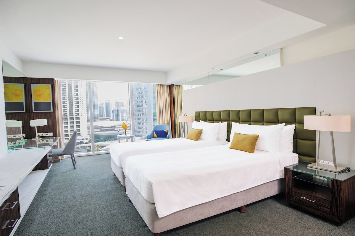 Ein Hotelzimmer mit einem großen Bett, einem Schreibtisch und einem Stuhl.