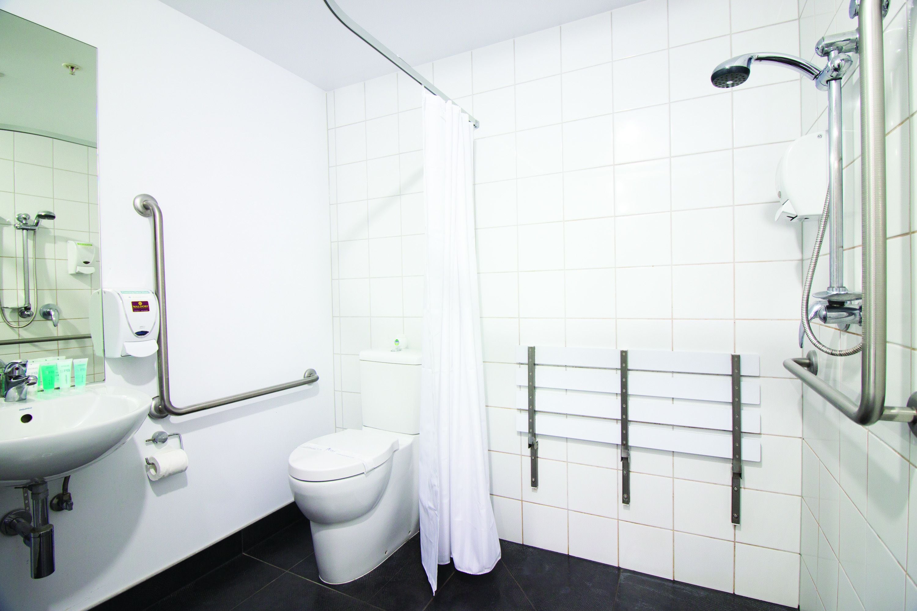 A bathroom with a white sink, toilet, and shower.
