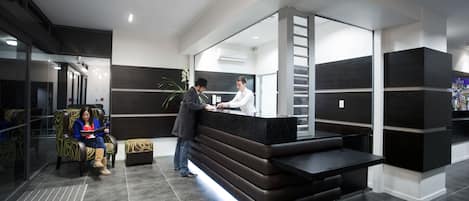 Un espace d’accueil moderne comprenant un comptoir, des sièges et un escalier.