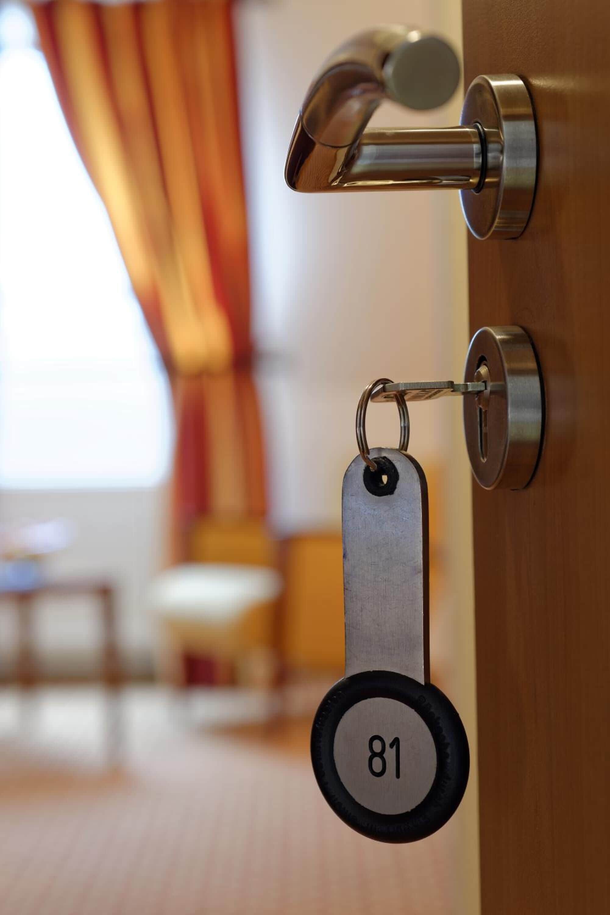 A door with a keyhole and a keychain with a number tag.