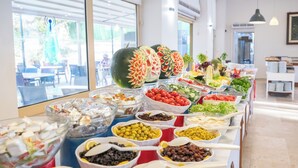 A buffet with various food items and a decorative watermelon. - Arora Hotel (Kusadasi)