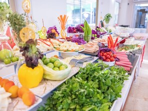 Ein reichhaltiges Buffet mit verschiedenen Speisen und frischem Gemüse.