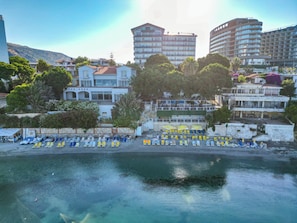 Ein Hotel an der Küste mit mehreren Etagen und verschiedenen Sitzgelegenheiten direkt am Strand.