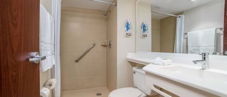 A modern bathroom with a shower, toilet, and sink.