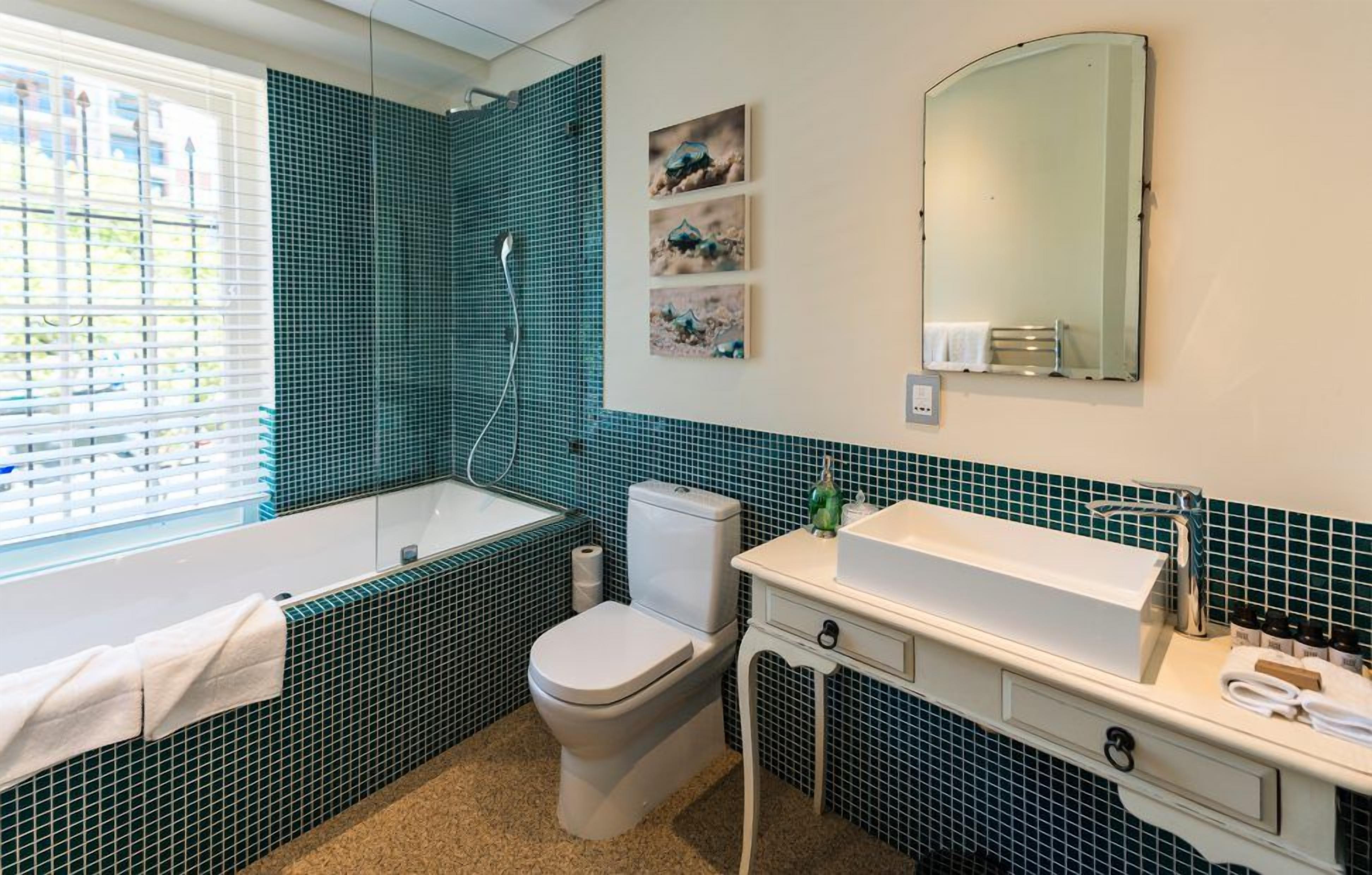 Une salle de bain avec une baignoire, des toilettes, un lavabo et un miroir.