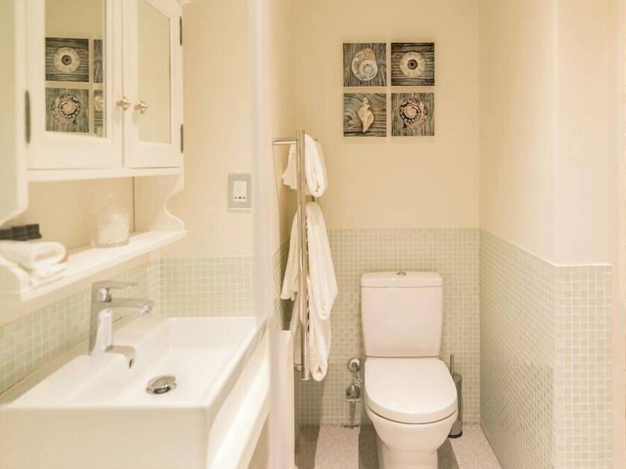 Un baño con lavamanos, inodoro y detalles decorativos en la pared.