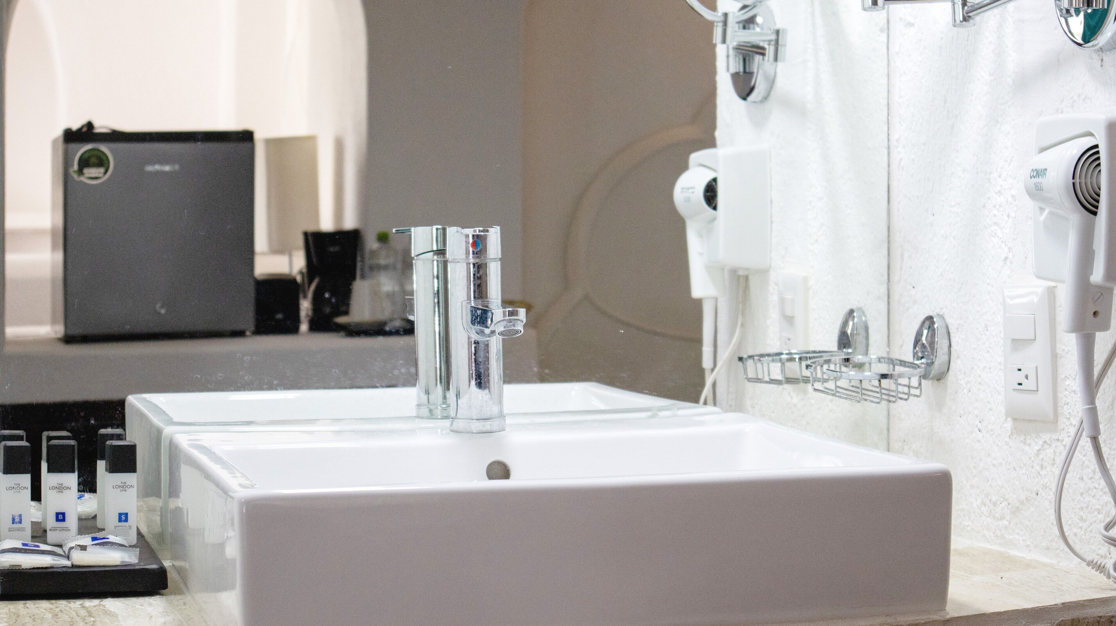 A bathroom with two sinks, a mirror, and a towel rack.