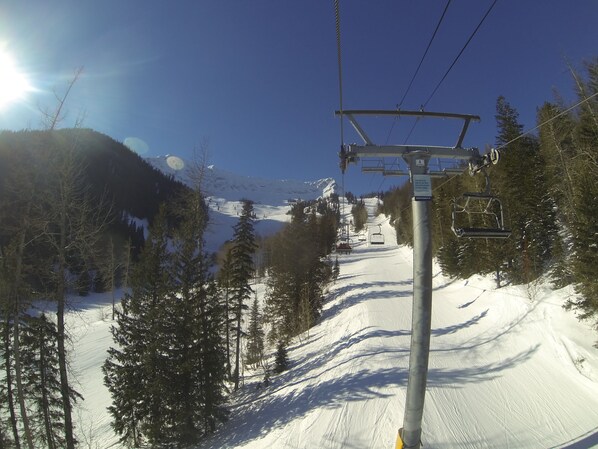 A ski lift with a cable system, surrounded by snow-covered slopes and evergreen trees. - Fernie Slopeside Lodge (Fernie)