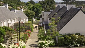 A residential street with houses, a pedestrian pathway, and lush greenery. - Belambra Clubs Trégastel - Le Castel Sainte Anne (Tregastel)
