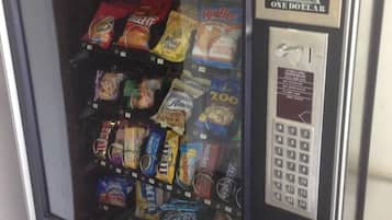 A vending machine with a keypad and a green display, containing various snack items.